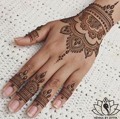 a woman's hand with henna tattoos on it