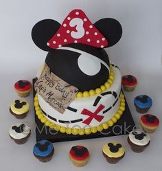 a mickey mouse birthday cake with cupcakes around it