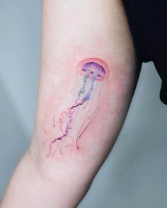 a small jellyfish tattoo on the arm