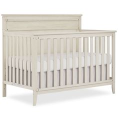 a baby crib with white sheets on the top and bottom, in front of a white background