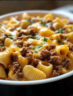 a close up of a bowl of pasta with meat and cheese on top, ready to be eaten