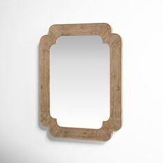 a wooden mirror hanging on the wall next to a white wall with a light brown frame