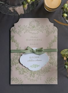 a wedding card with a green ribbon on it