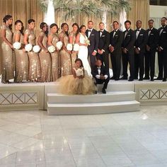 a group of people in formal wear posing for a photo on the steps at a wedding