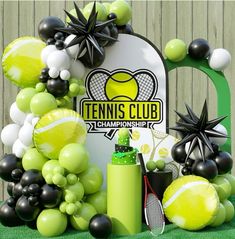 a tennis themed backdrop with balloons and balls