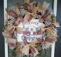 a welcome to our camper wreath is hanging on the front door with burlocks