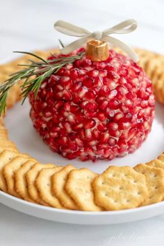 a pomegranate ball on a plate with crackers