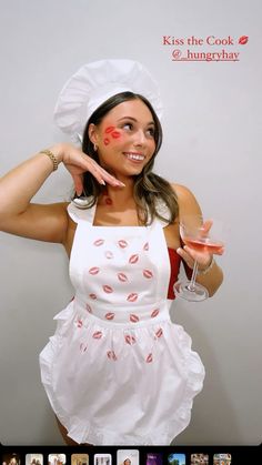 a woman in a white dress holding a wine glass and pointing to the side with her finger