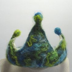 there is a felt crown on top of a mannequin's head wearing a blue and green hat