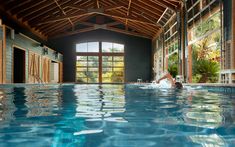 a large indoor swimming pool with blue water