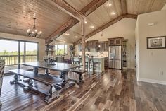 a large open floor plan with wood floors and wooden ceilinging in the kitchen area