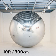 a large silver ball in the middle of a room with white walls and ceilinging