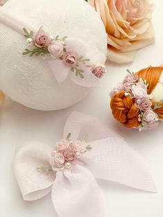 two flowered hair clips on top of a white ball with pink flowers in it