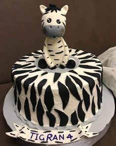 a zebra cake is decorated with black and white icing on the top, sitting on a plate