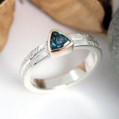 a silver ring with a blue stone in the middle