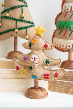 three burlap christmas trees are on display