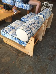 a person sitting on a blue and white couch in a room with other furniture around