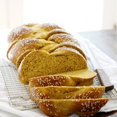 a loaf of bread sitting on top of a cooling rack next to slices of bread