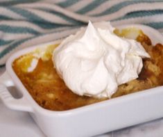 a close up of a dish of food with whipped cream on top and a towel in the background