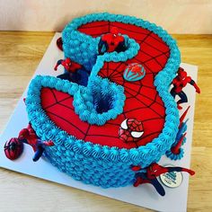 a spiderman birthday cake with blue frosting