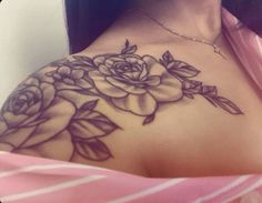 a woman with a rose tattoo on her shoulder and chest is looking at the camera