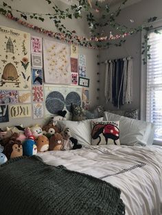 a bed with lots of stuffed animals on top of it and hanging from the ceiling