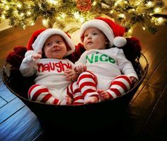 two babies wearing santa hats sitting in a basket