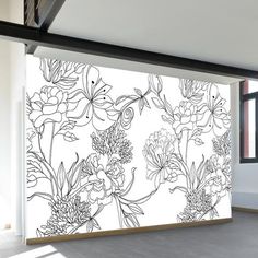 a wall with flowers painted on it in an empty room next to a large window