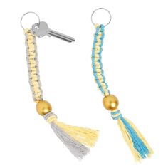 two key chains with tassels and beads on each end, one has a gold ball