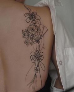 a woman's back with flowers on it and the words done at @popmbc