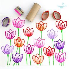 some flowers are drawn on a piece of paper with tape next to them and two rolls of toilet paper