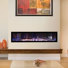 a modern fireplace in a living room with art on the wall