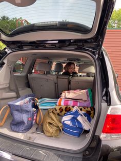 the back end of a car filled with bags and purses on top of it