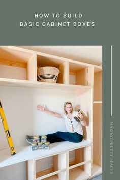 a woman sitting on top of a white table next to a shelf filled with boxes