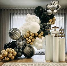 black, gold and white balloons are on display