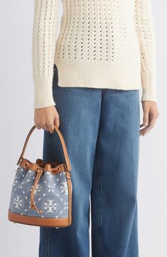 Logo-patterned denim and smooth leather provide textural interplay on this bucket bag featuring a drawstring closure cinched with a logo-embellished toggle. Drawstring closure Top carry handle; removable, adjustable crossbody strap Exterior slip pocket Interior wall pocket Protective metal feet Lined Cotton with leather trim Imported Denim Bucket Bag, Patterned Denim, T Monogram, Interior Wall, Wall Pockets, Crossbody Strap, Leather Trim, Smooth Leather, Leather Trims