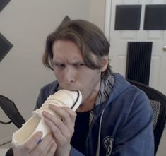 a man sitting at a desk eating a banana