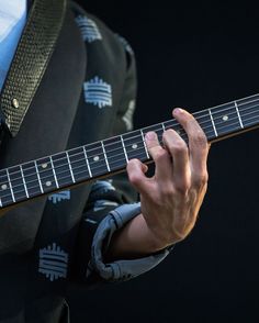 a close up of a person playing an electric guitar