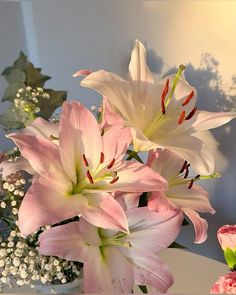 pink and white flowers in a vase on a table