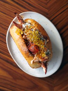 a hot dog on a plate with mustard and ketchup sprinkled all over it