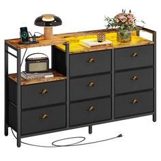 a black dresser with drawers and a yellow counter top next to a flower pot on a table