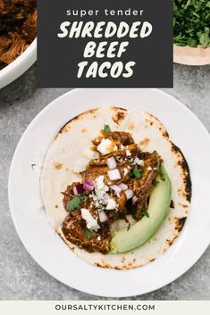 shredded beef tacos with avocado on the side and text overlay that reads super tender shredded beef tacos