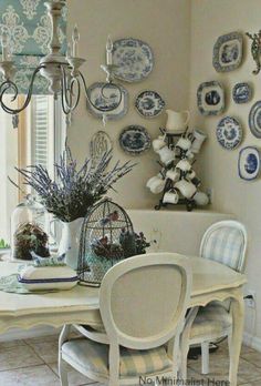 a dining room table with blue and white plates on the wall