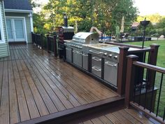 an outdoor bbq grill on a wooden deck