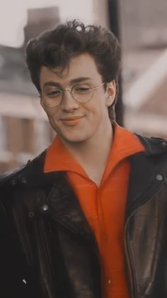 a man wearing glasses and an orange shirt