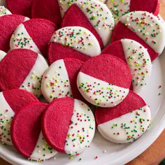 red and white cookies with sprinkles are arranged on a plate, ready to be eaten