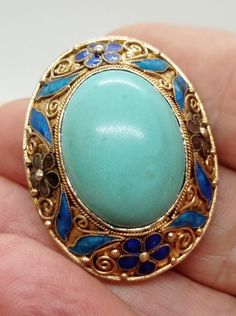 Chinese export 60s gold sterling silver brooch with large turquoise cabochon and blue enamel, 60s turquoise silver enamel brooch Vintage 60s marked sterling materials: sterling silver gold and gemstone - beautiful color turquoise, dark blue and sky blue enamel cabochon measures: 2.5x2 cm without flaws Brooch measures 4x3.5 cm Pretty floral decoration in dark blue, sky blue, brown enamel Excellent condition! Here is a beautiful gilt sterling silver filigree and enamel brooch. Brooch was made for Turquoise Brooch For Formal Occasions, Collectible Hallmarked Blue Brooches, Antique Blue Jewelry With Brooch, Blue Cabochon Brooch For Formal Occasions, Formal Blue Cabochon Brooch, Vintage Turquoise Enamel Jewelry, Antique Blue Enamel Brooches, Antique Handmade Blue Brooches, Turquoise Cabochon Brooch For Gift