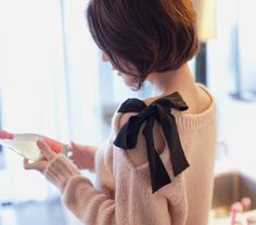 a girl in a sweater looking at her cell phone with the caption'try this take an old sweater cut a bit in along the shoulder down about 7 '