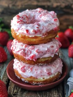 three strawberry donuts stacked on top of each other