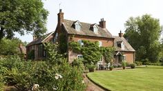 a large brick house surrounded by lush green grass